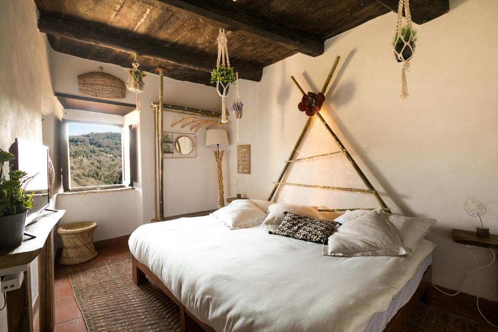 ein Schlafzimmer mit einem großen weißen Bett in einem Zimmer in der Unterkunft Opera Suites - Il sentiero della felicità in Calcata