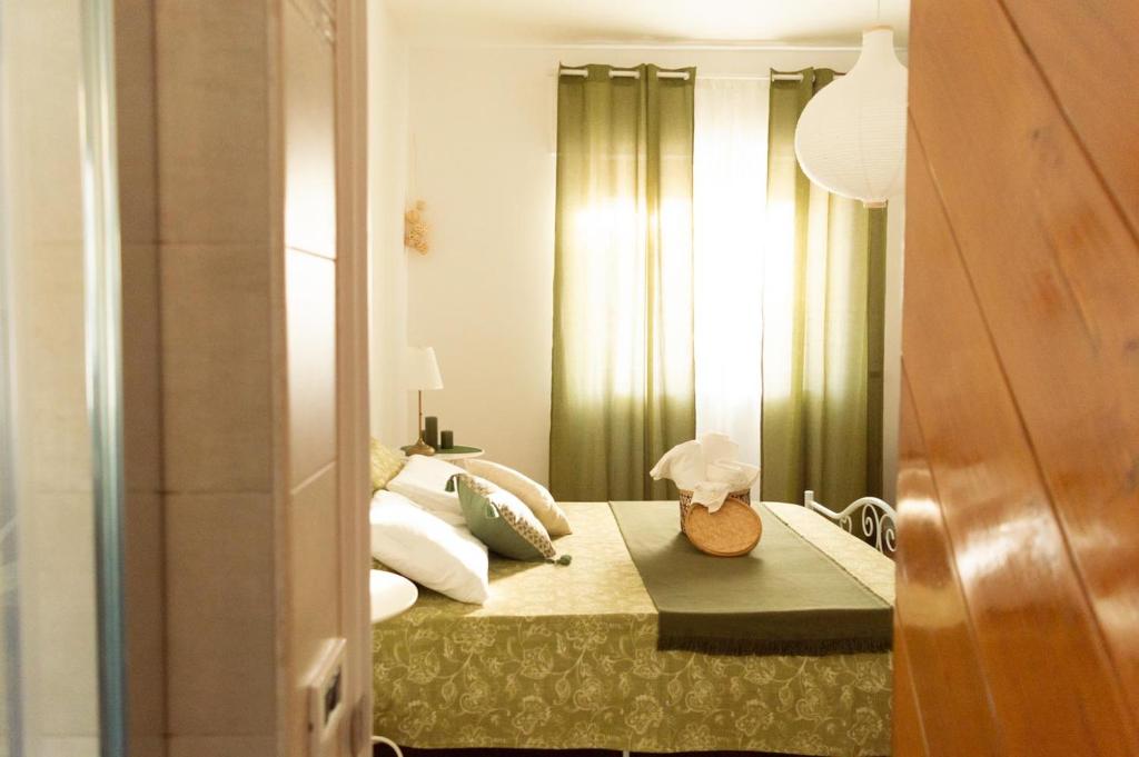 a bedroom with a bed with green curtains at PURA B&b in Noicattaro