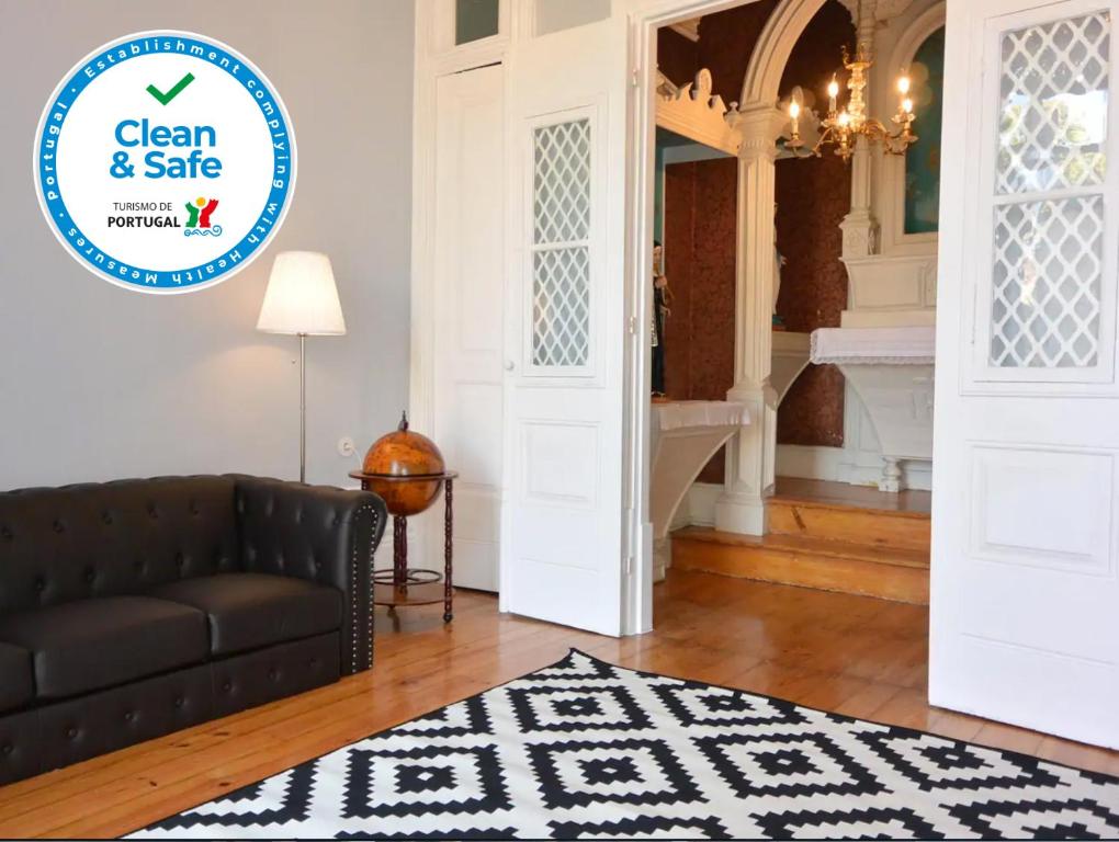 a living room with a couch and a sign that reads clean and safe at Bonjardim 466 - Historic Townhouse in Porto