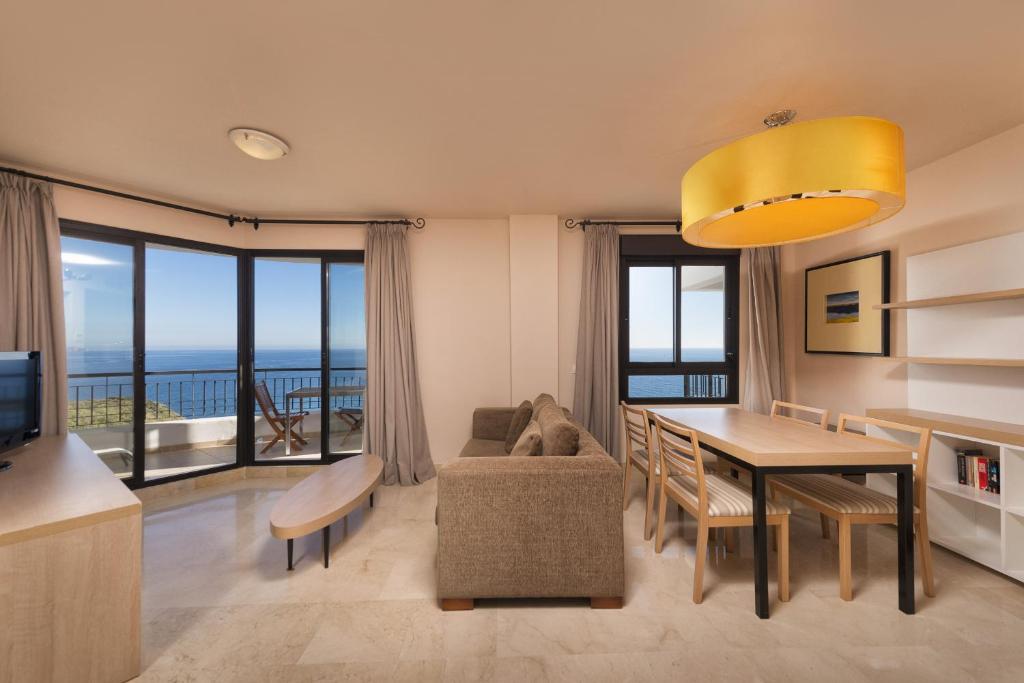 a living room with a dining room table with a view at Apartamento vista mar frontal garaje y WiFi in Torrox Costa