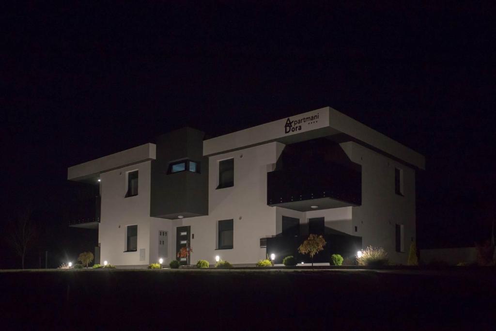 a large white building with a sign on it at night at Apartments Dora Sveti Martin na Muri in Sveti Martin na Muri