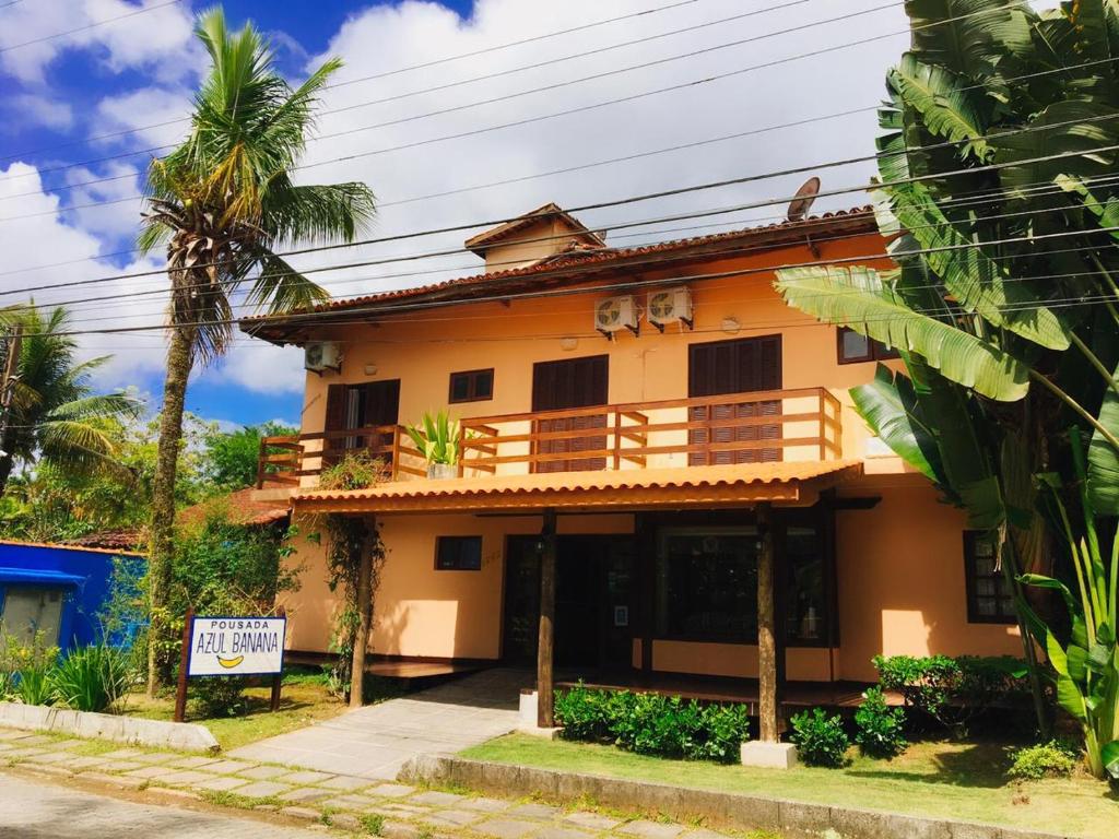 a house with a sign in front of it at Pousada Azul Banana - Camburi in Camburi