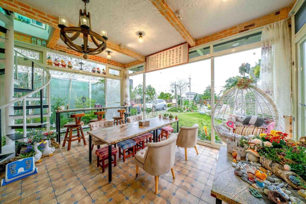 a dining room with a table and chairs and a large window at 花蓮 達芙妮花園民宿 in Ji&#39;an