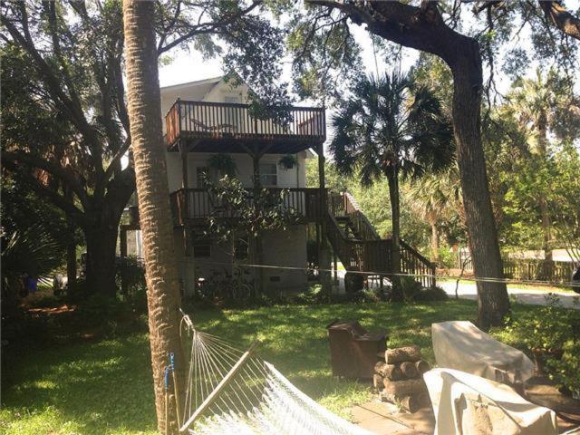 a house with a porch and a balcony on it at The Treehouse at 10th in Folly Beach