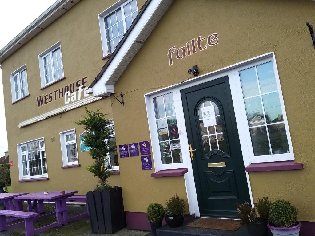 uma entrada frontal para um restaurante com uma porta verde em Westhouse Cafe em Longford