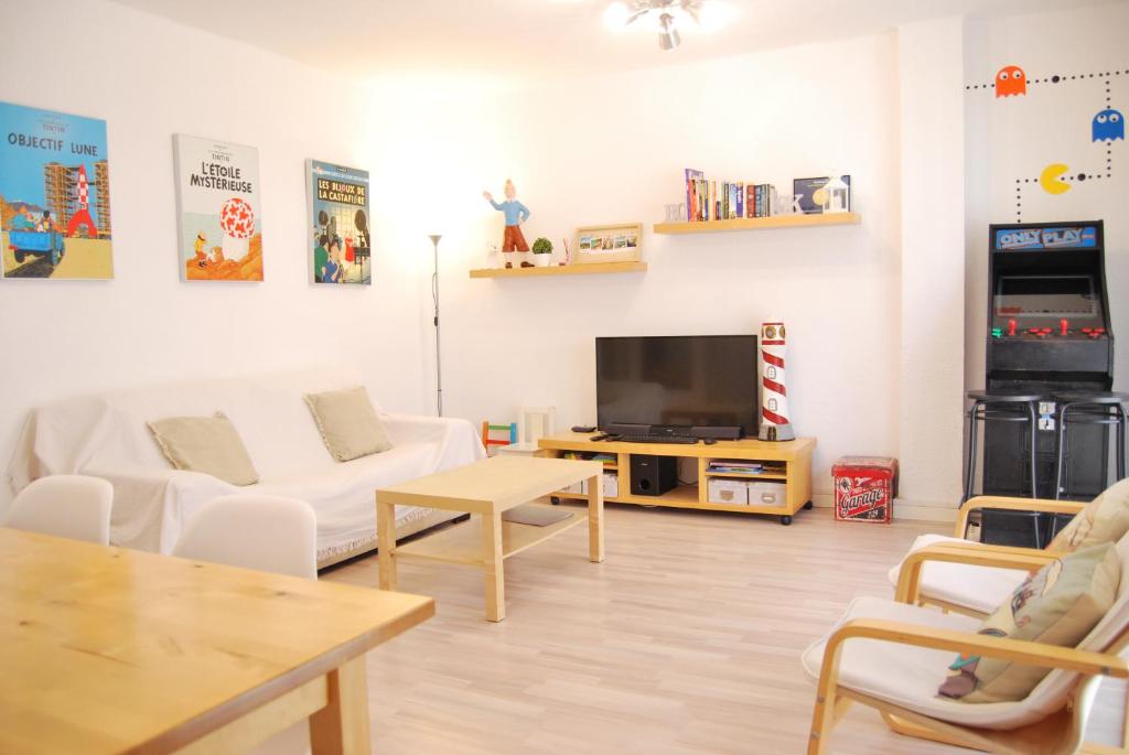 ein Wohnzimmer mit einem weißen Sofa und einem TV in der Unterkunft Apartamento en Cambrils Puerto,con Parking in Cambrils