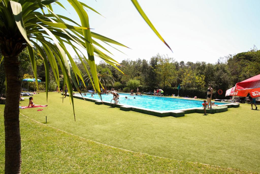 a large swimming pool with people in a park at Camping 3 Estrellas Costa Brava in Vall-Llobrega