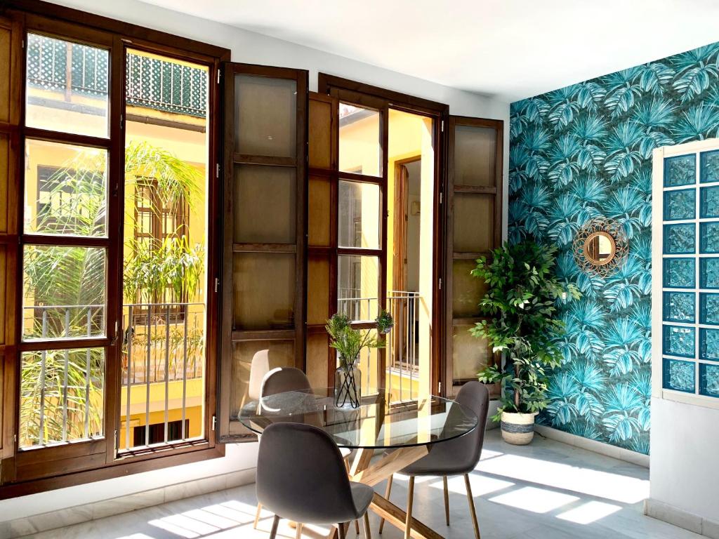 a dining room with a glass table and chairs at Homely Málaga Pozos Dulces 27 centro histórico in Málaga