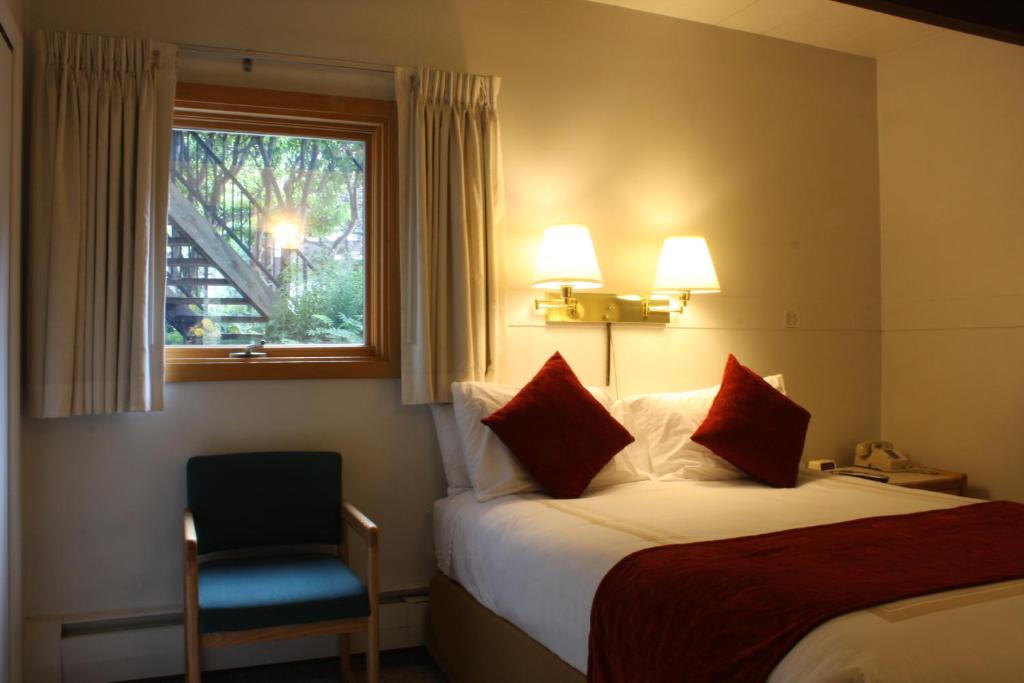 Habitación de hotel con cama, silla y ventana en St Moritz Lodge and Condominiums en Aspen