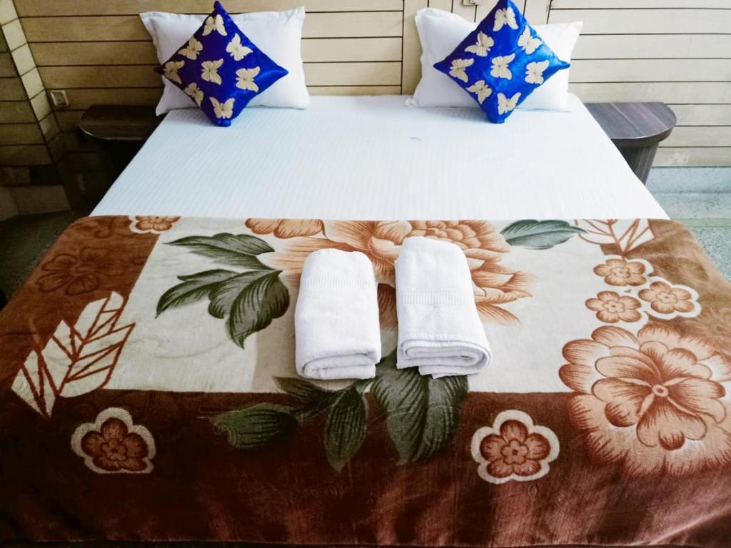 Una cama con almohadas y toallas. en Hotel marwari niwas en Haridwār
