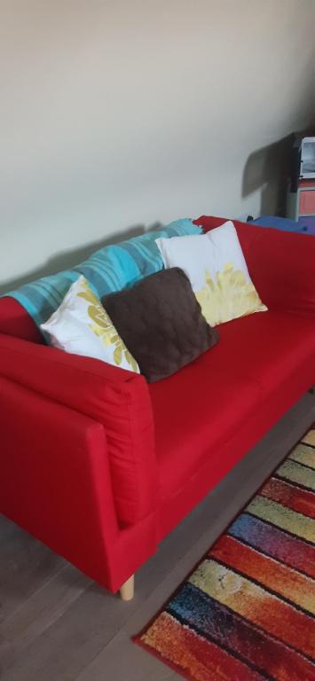 a red couch sitting on top of a rug at The Saracens Head THE CONKERA in Chapel Saint Leonards