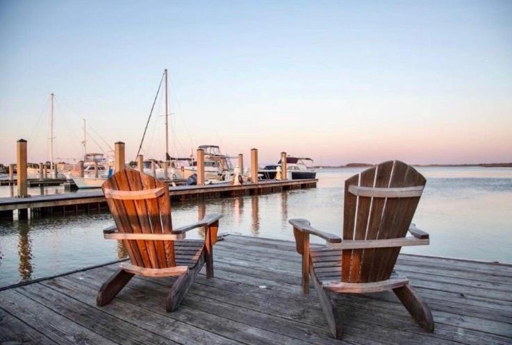 two chairs sitting on a dock near the water at The Southern Harmony in Folly Beach