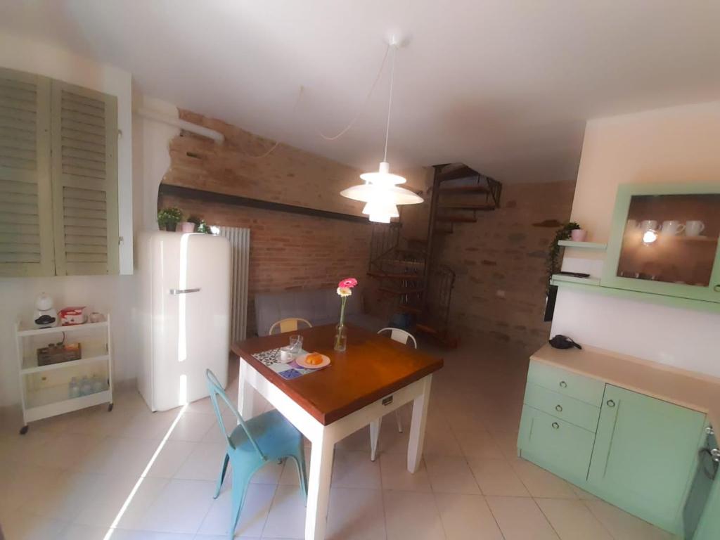 uma cozinha com uma mesa de madeira e um frigorífico em La Casina del Porto em Fano