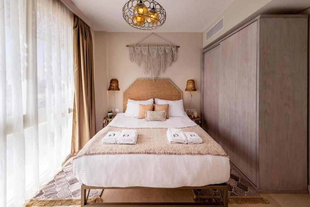 ein Schlafzimmer mit einem großen Bett mit zwei Handtüchern darauf in der Unterkunft Gleaming 1 BR Apt Mangroovy w Pool & Beach Access in Hurghada