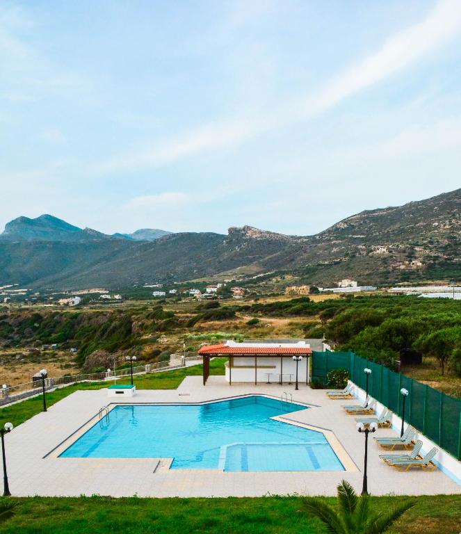 a swimming pool with a gazebo and mountains at Panorama Hotel in Falasarna