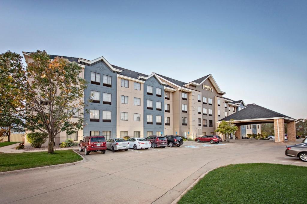 a large building with cars parked in a parking lot at Staybridge Suites - Cedar Rapids North by IHG in Cedar Rapids