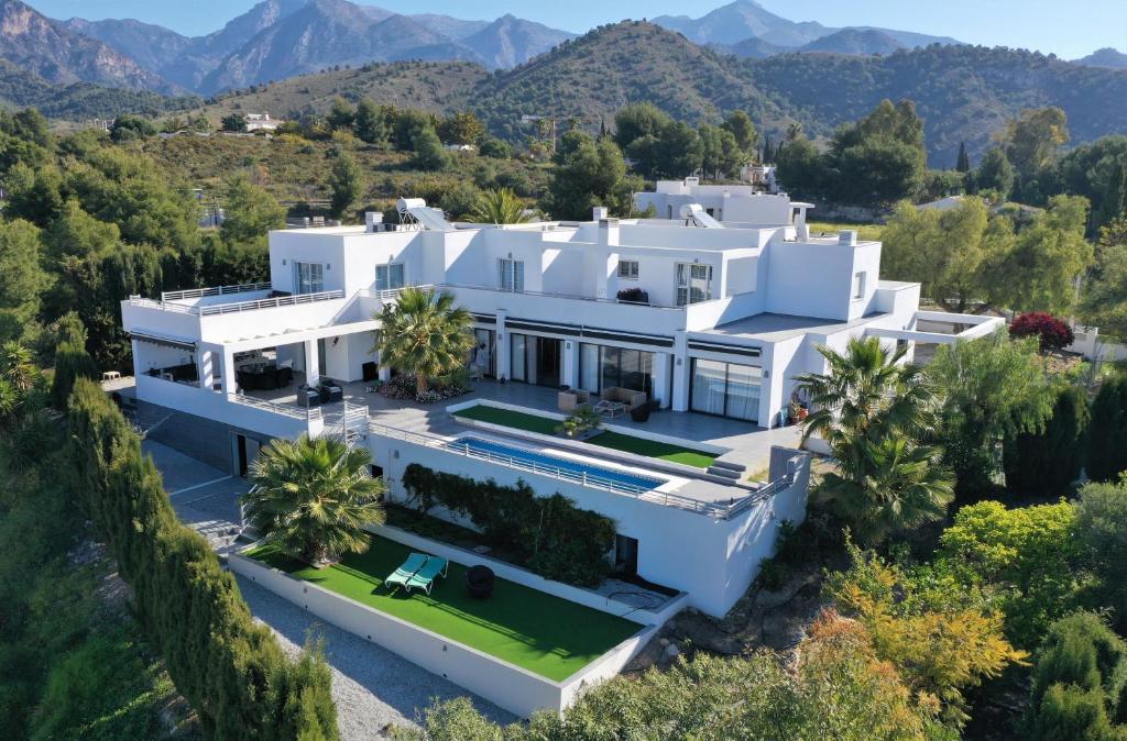 una vista aérea de una casa blanca con árboles y montañas en Bed and Breakfast Villa Corte Azul, en Frigiliana