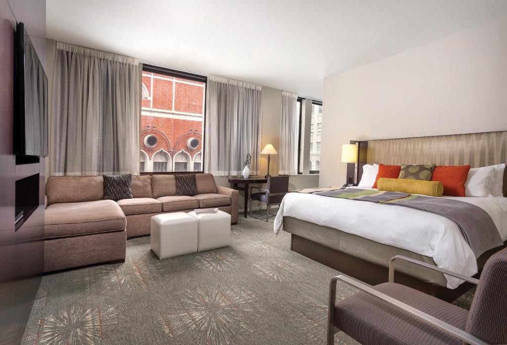 a hotel room with a bed and a couch at The Donatello Hotel in San Francisco