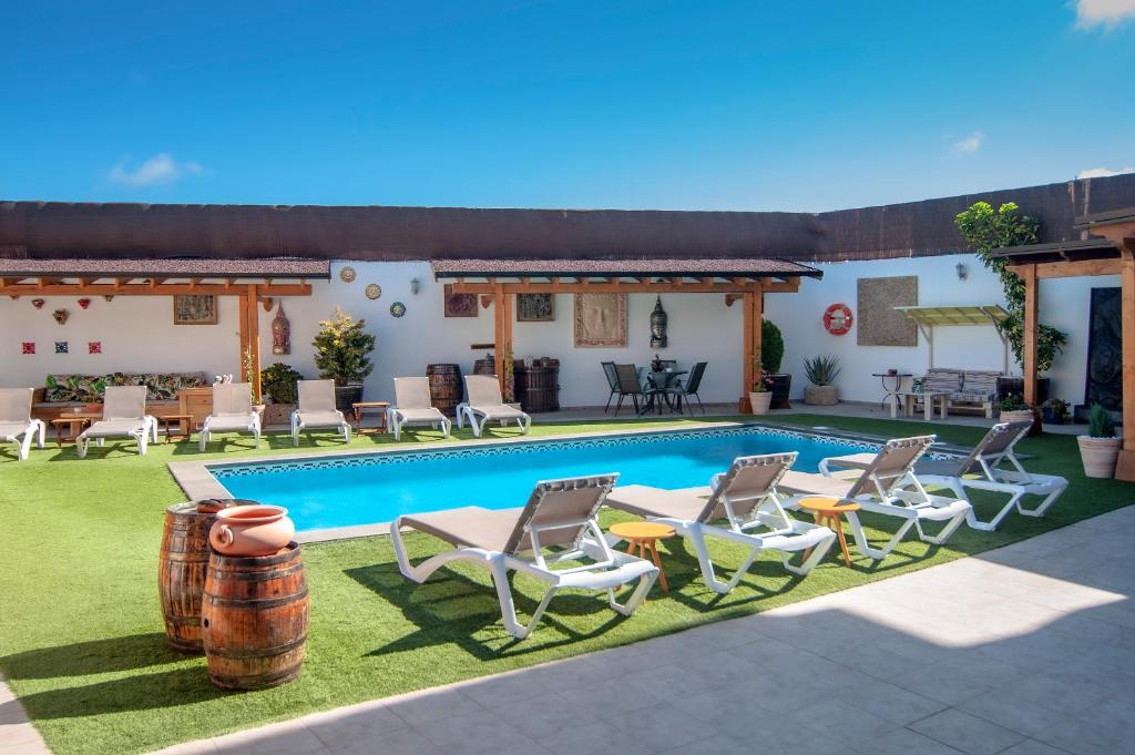 a villa with a swimming pool and lounge chairs at Casa Mercedes in El Río