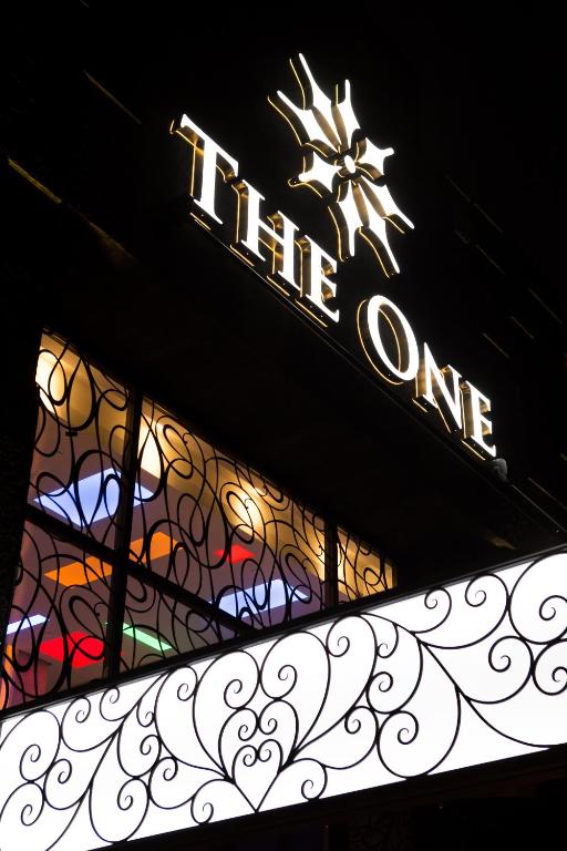 a lit up sign on top of a building with a sign at The One Boutique Hotel in Queens