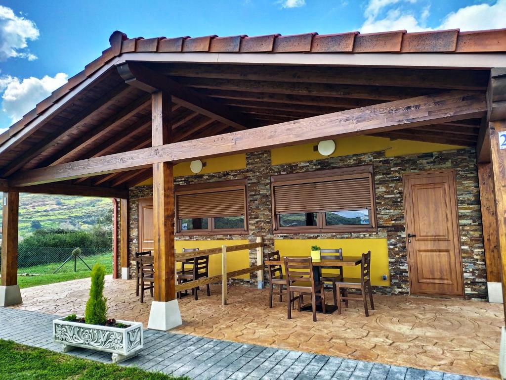 a wooden pavilion with tables and chairs on a patio at Apartamentos El Prau in Ubiarco