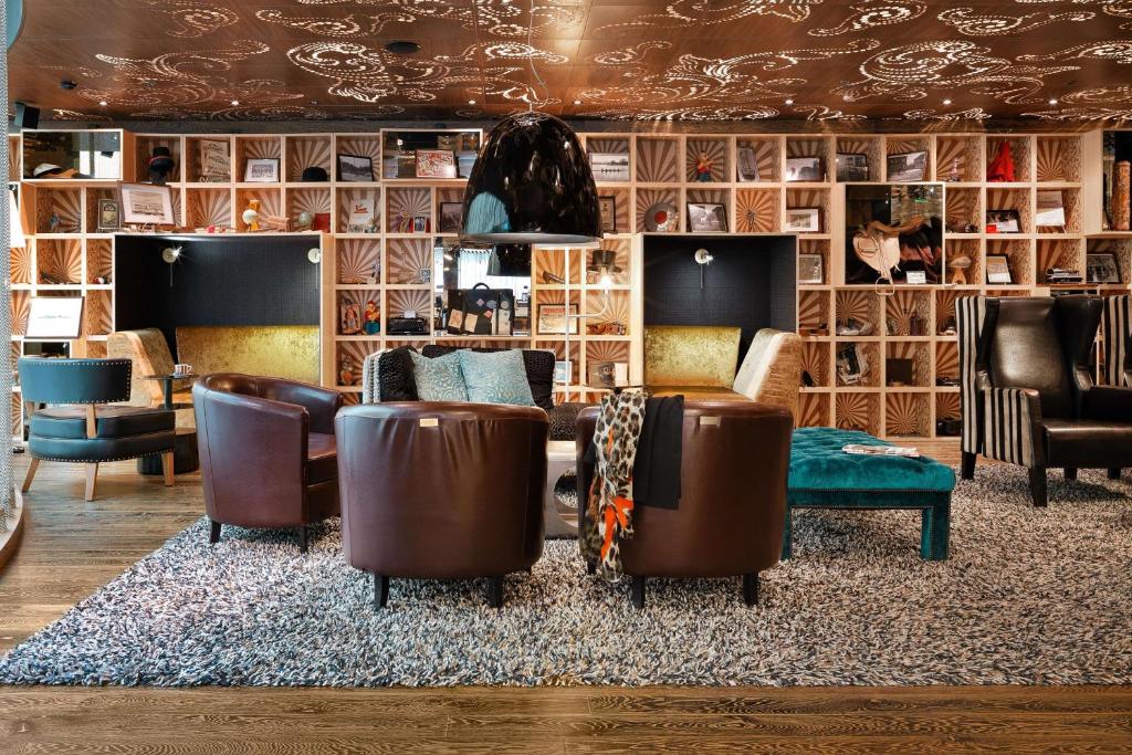 uma sala de estar com sofás e cadeiras num tapete em Scandic Paasi em Helsínquia