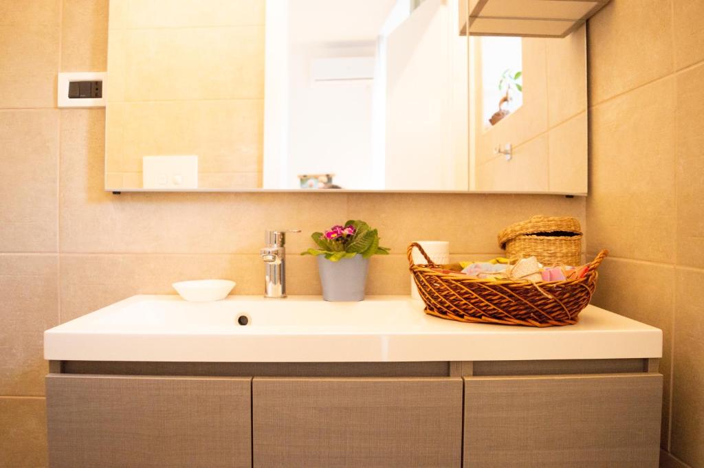 a bathroom sink with a basket on top of it at PURA B&b in Noicattaro