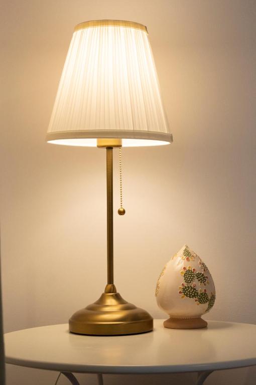 a lamp on a table with a vase on it at PURA B&b in Noicattaro