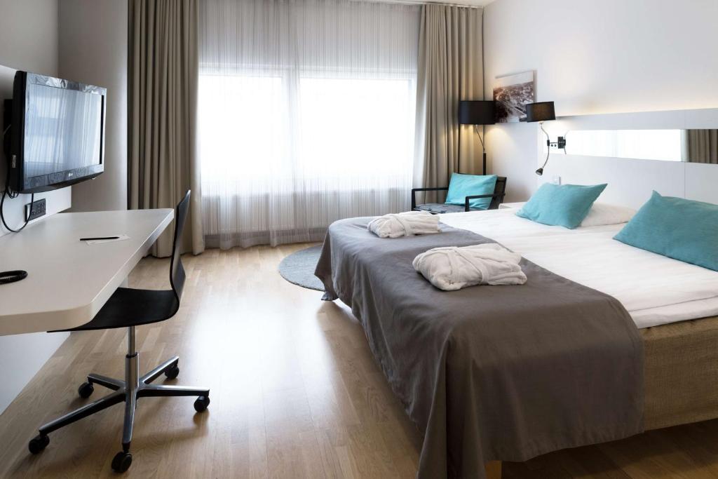 a hotel room with two beds and a desk at Scandic Julia in Turku