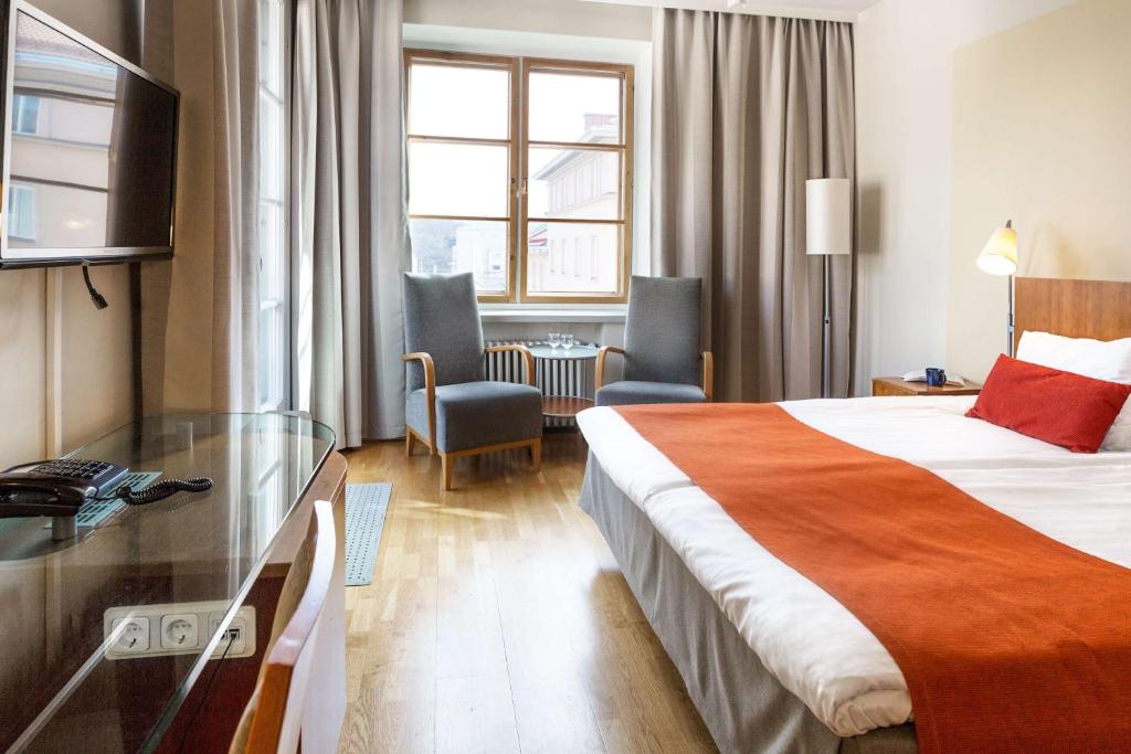トゥルクにあるスカンディック プラザ トゥルクのベッドとガラスのテーブルが備わるホテルルームです。