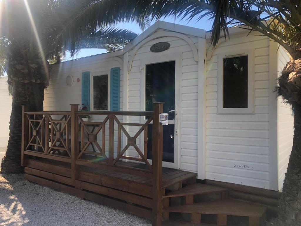 une petite maison avec une terrasse couverte et une terrasse dans l'établissement FLAMANTS ROSES 2, à Frontignan