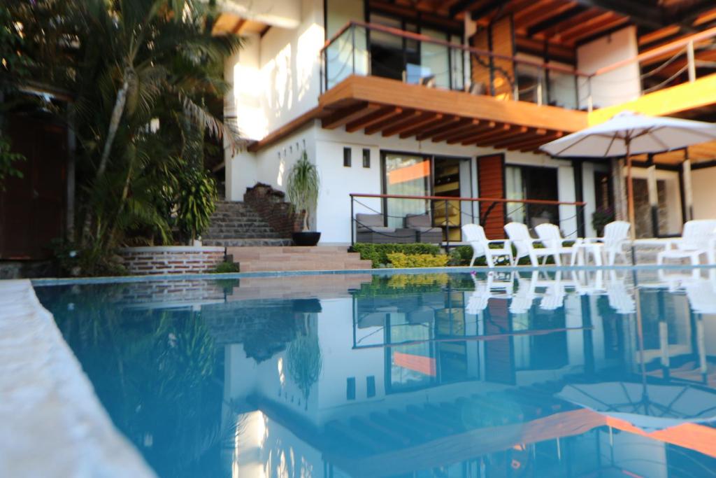 una casa con piscina con sedie e ombrellone di Casa Acento a Valle de Bravo