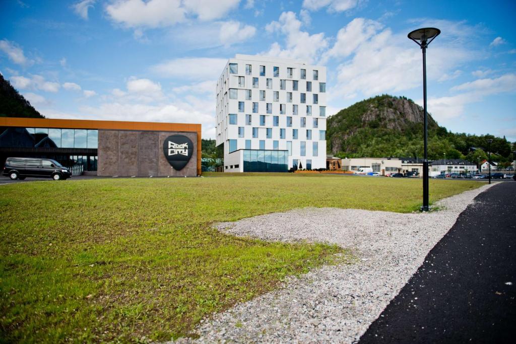 a building with a grass field and a street light at Scandic Rock City in Namsos
