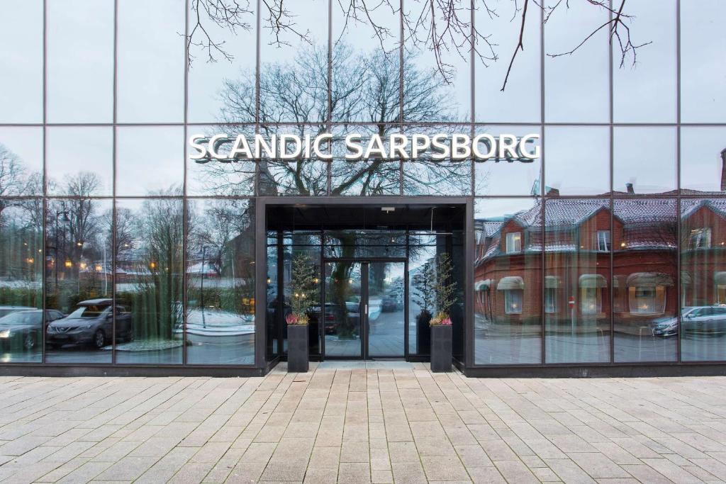 un gran edificio de cristal con un cartel. en Scandic Sarpsborg, en Sarpsborg