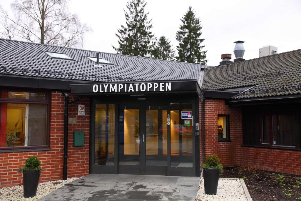 um edifício com uma placa na frente dele em Olympiatoppen Sportshotel - Scandic Partner em Oslo