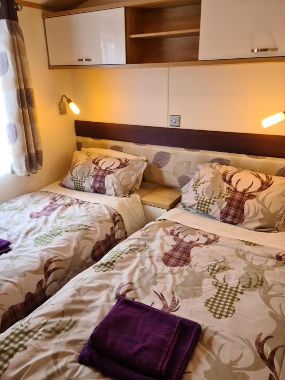 two beds sitting next to each other in a room at Deer lodge in Auchterarder