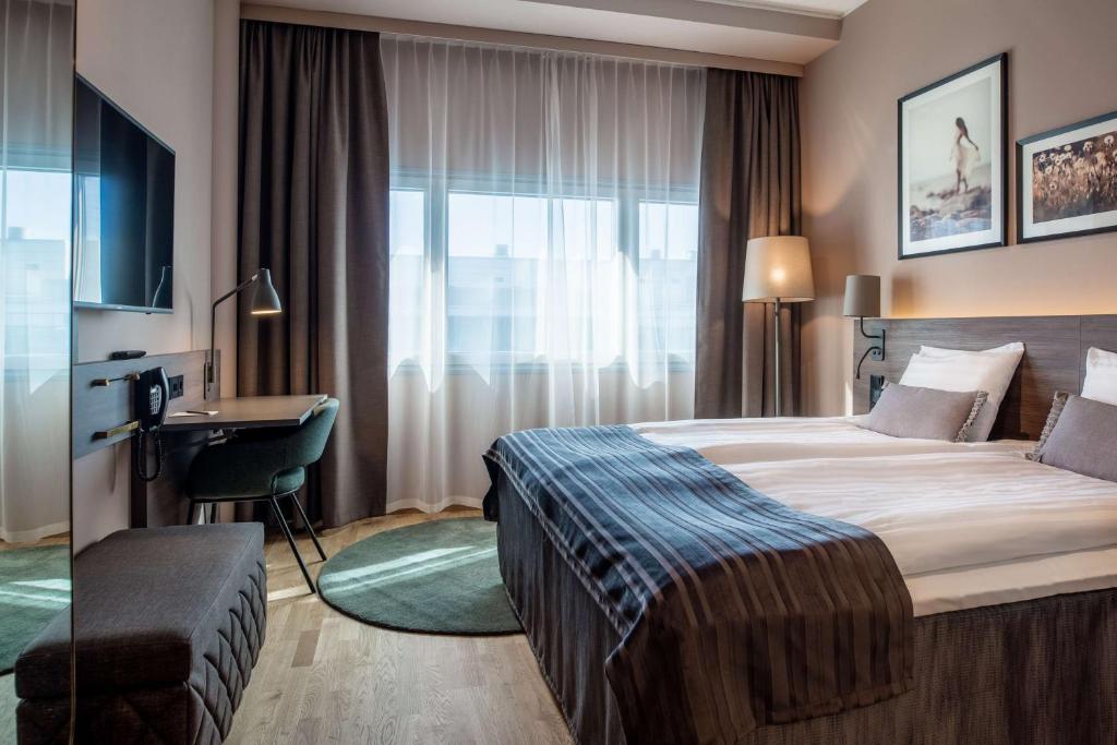 um quarto de hotel com uma cama e uma secretária em Scandic Helsinki Airport em Vantaa