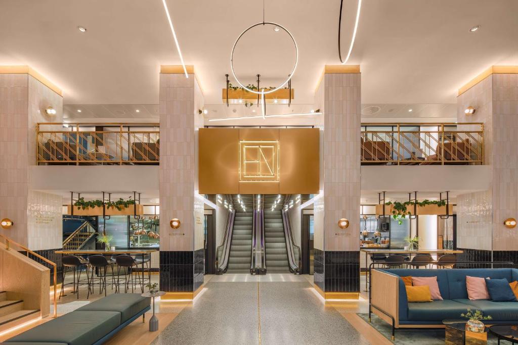 a lobby of a hotel with couches and a restaurant at Hotel Norge by Scandic in Bergen