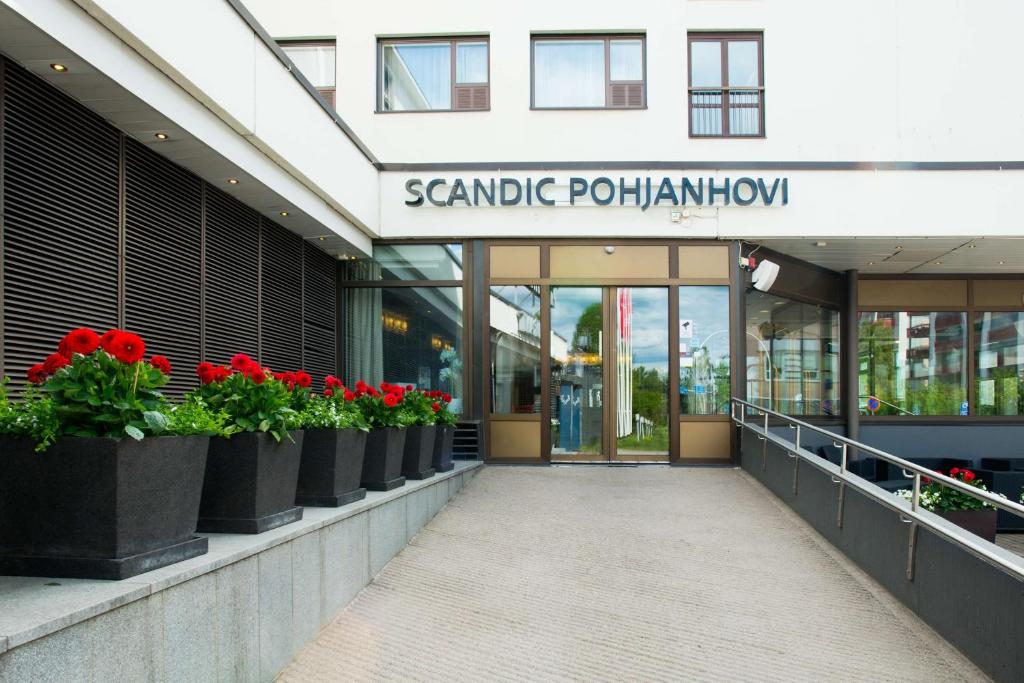 a facade of a building with red flowers in pots at Scandic Pohjanhovi in Rovaniemi