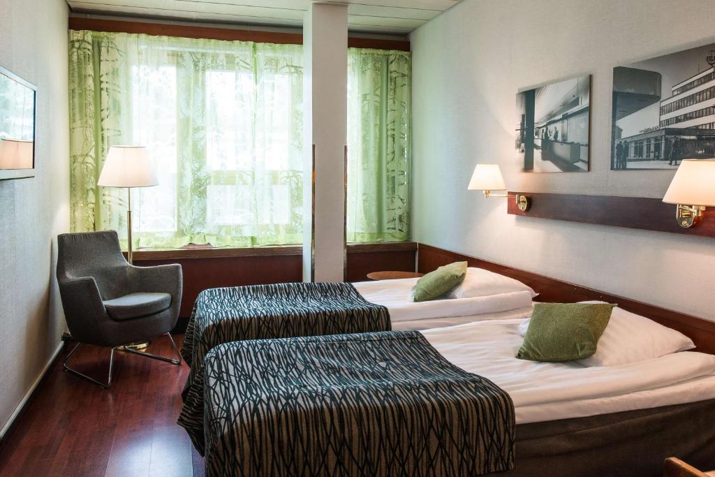 una habitación de hotel con 2 camas y una silla en Scandic Polar, en Rovaniemi