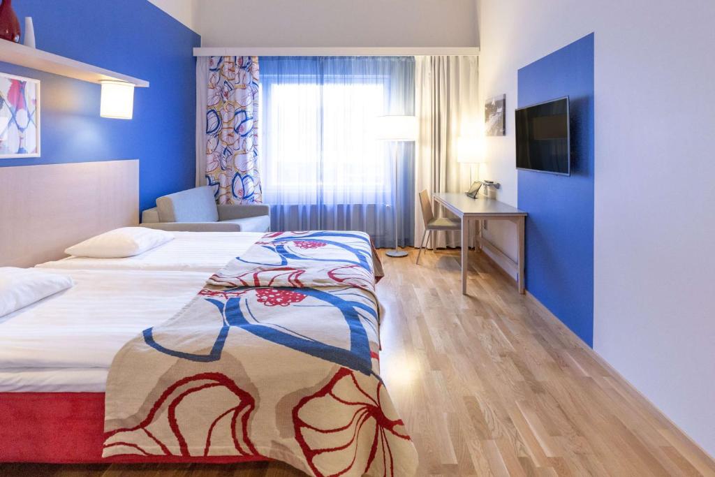ein Hotelzimmer mit 2 Betten und einem TV in der Unterkunft Scandic Hyvinkää in Hyvinkää