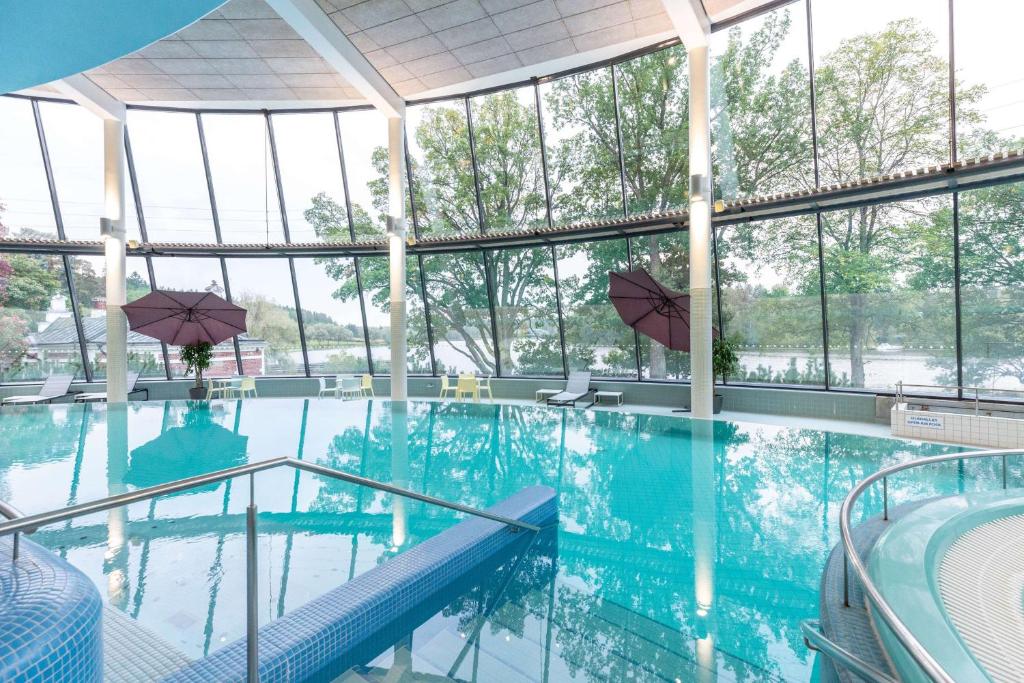 a swimming pool with a person sitting in the water at Scandic Aulanko in Hämeenlinna