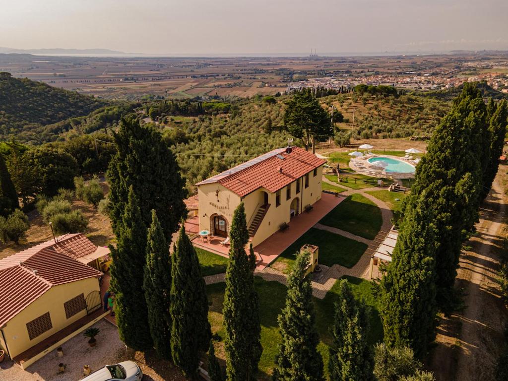 eine Luftansicht eines Hauses mit Pool und Bäumen in der Unterkunft Agriturismo Mercurio in Campiglia Marittima