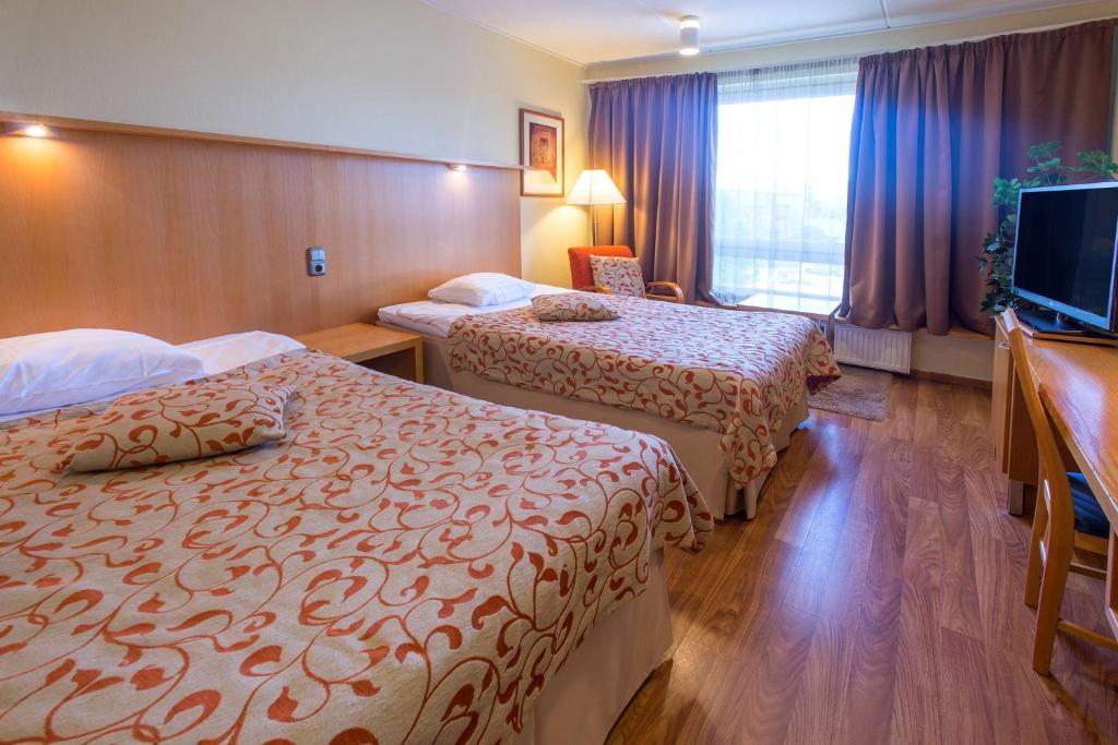 ケミにあるScandic Kemiのベッド2台、薄型テレビが備わるホテルルームです。