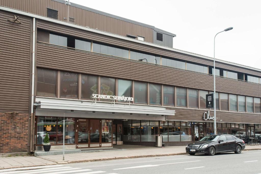 een auto geparkeerd voor een gebouw bij Scandic Seinäjoki in Seinäjoki