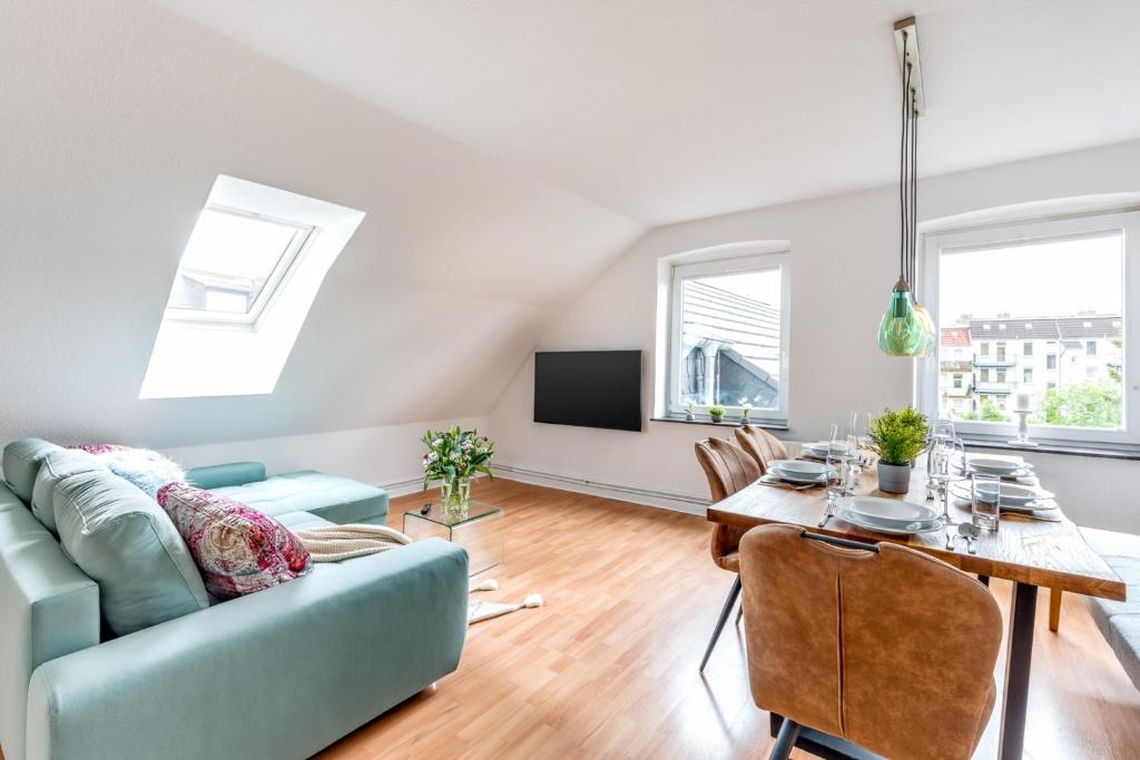 uma sala de estar com um sofá azul e uma mesa em Madame Flens - komfortable Wohnung mit 3 Schlafzimmern im 3 OG em Flensburg