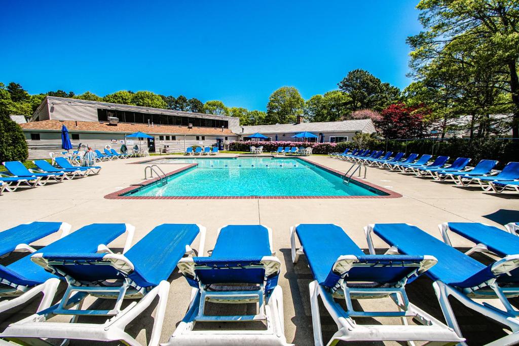 a group of blue lounge chairs and a swimming pool at Sea Mist Resort, a VRI resort in Mashpee