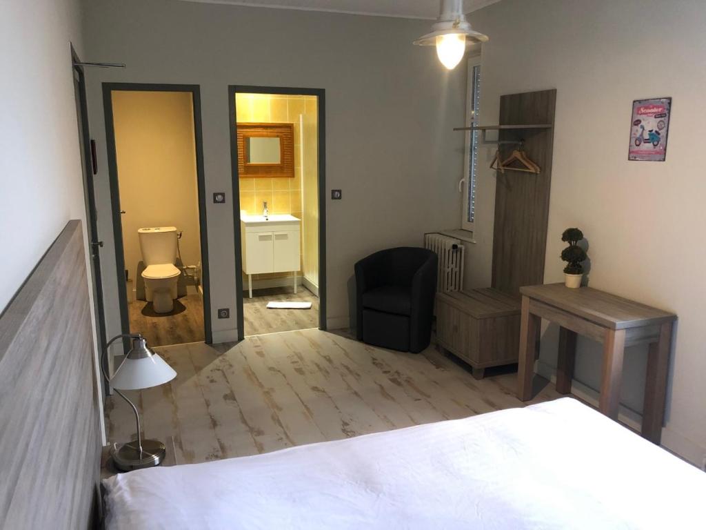 1 dormitorio con cama, silla y escritorio en AUBERGE DU CANAL, en Houdelaincourt