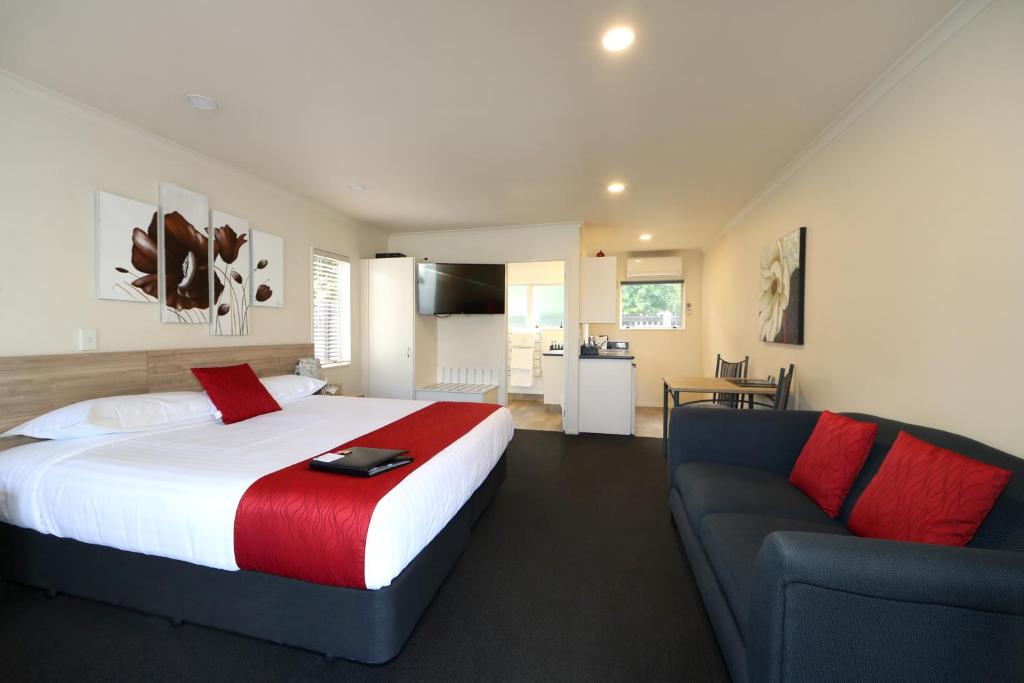 a bedroom with a large bed and a couch at Havelock North Motor Lodge in Havelock North