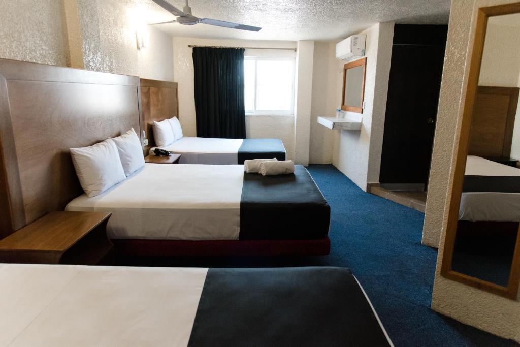 a hotel room with two beds and a chair at Hotel Central Irapuato - Hotel en Irapuato in Irapuato